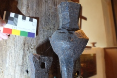 North centre turret post. Compass drawn design behind three bell clappers. Viewed from the west,